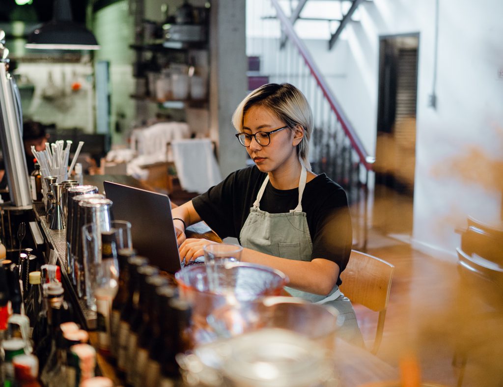 Restaurant or bar operator using Focus on her laptop.